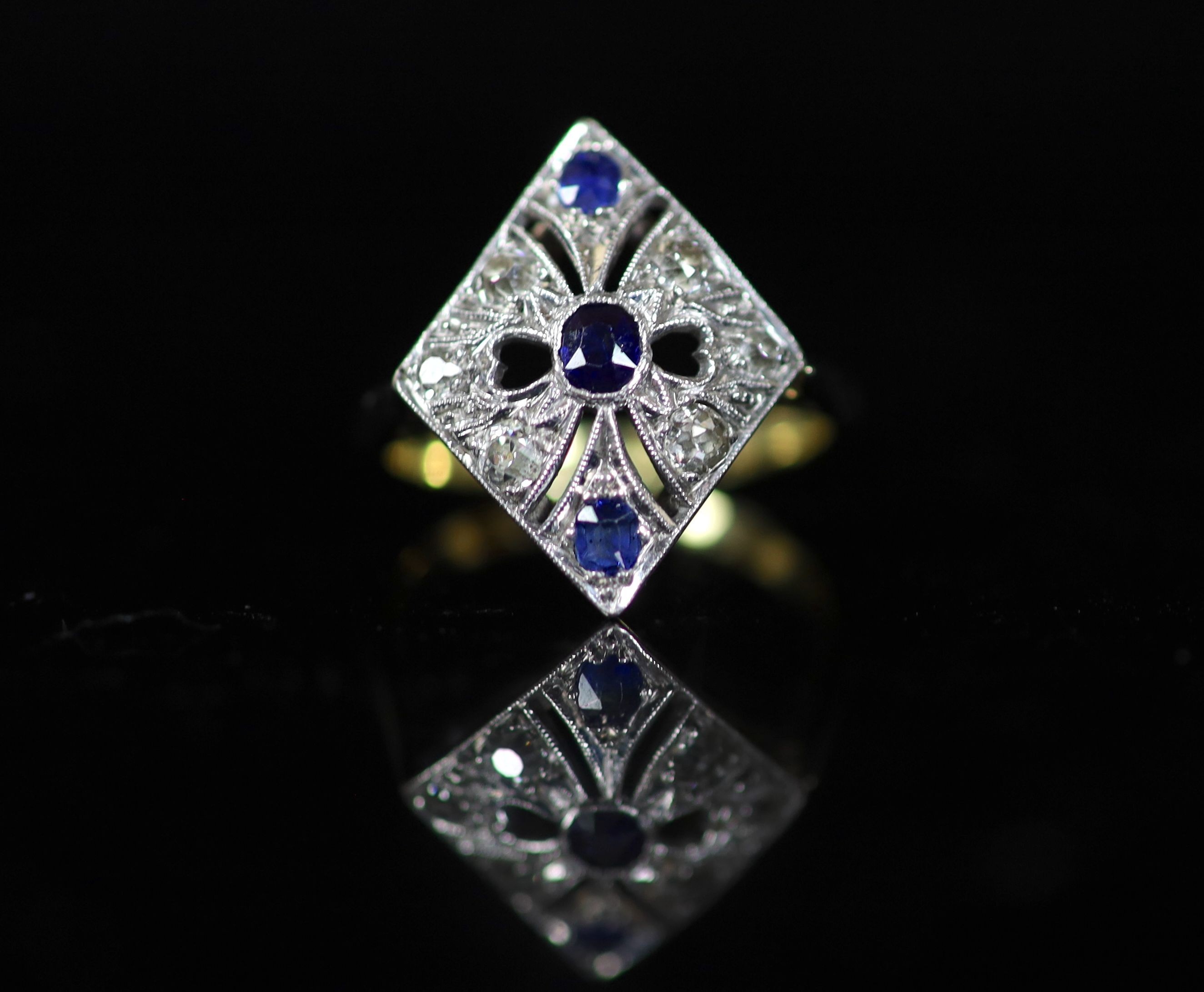 A 1920's/1930's 18ct gold and platinum, millegrain set sapphire and diamond pierced diamond shaped dress ring